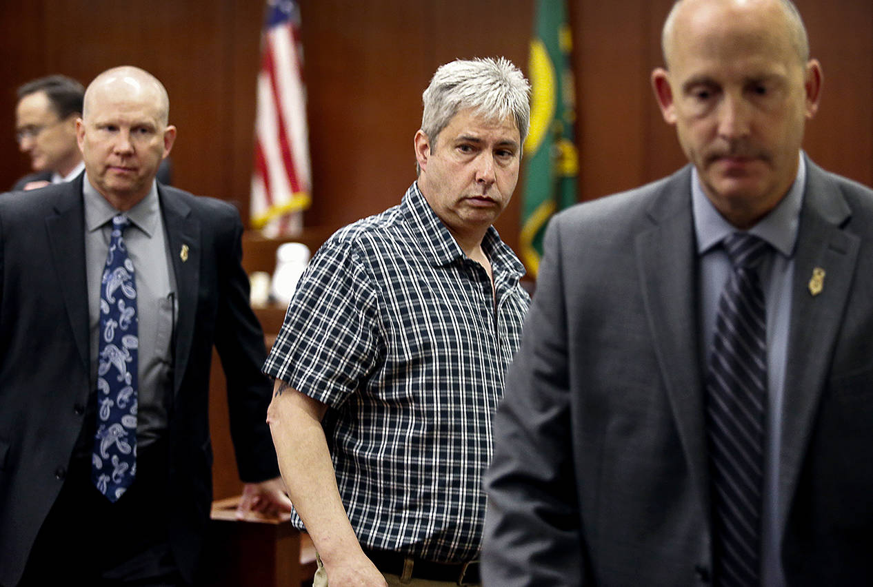 Tony Reed (center) leaves the courtroom during a jury break, glancing toward the seating area for the families of victims Monique Patenaude and Patrick Shunn. (Dan Bates / The Herald)