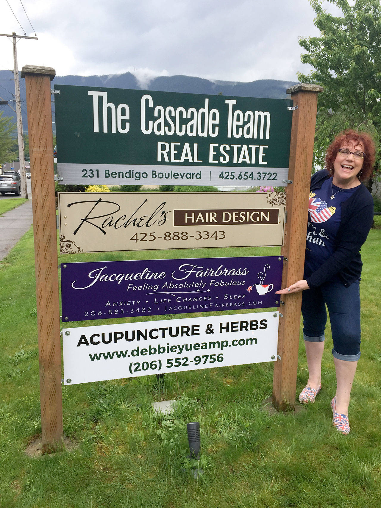 Jacqueline Fairbrass stands by the sign to her new office at 231 Bendigo Boulevard N, North Bend. Courtesy photo.