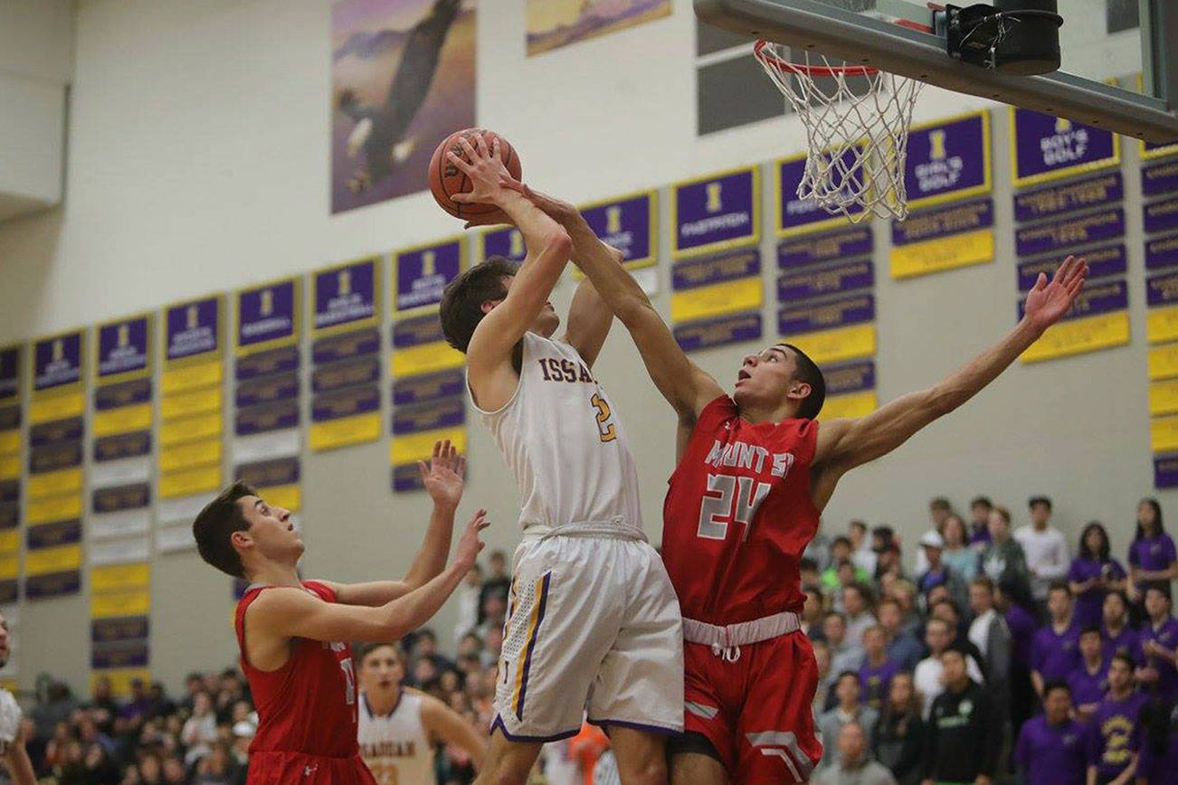 Mount Si Wildcats player Bijon Sidhu, right, tries to block a shot against Issaquah forward Will Farmer in a KingCo 4A contest between rivals on Jan. 5. The Wildcats finished the 2017-18 season with an overall record of 13-11.                                Photo courtesy of Don Borin/Stop Action Photography