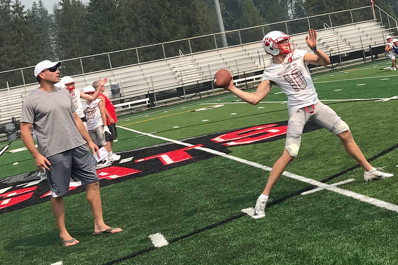 Mount Si Wildcats senior quarterback Cale Millen, center, unleashes pass deep down the right sideline on the first day of practice on Aug. 15. Millen will play college football at the University of Oregon next year. Shaun Scott/staff photo