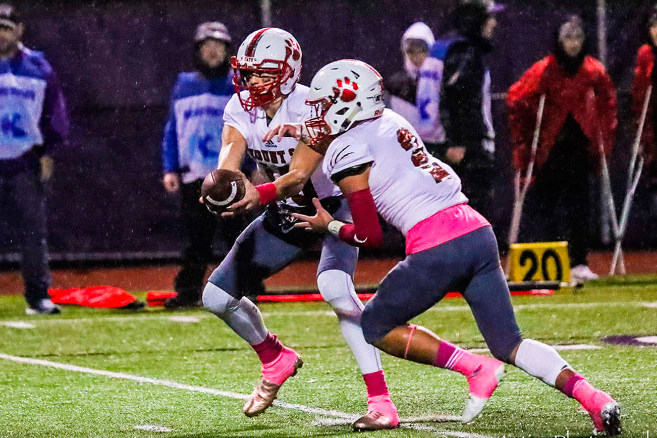 Mount Si Wildcats senior quarterback Cale Millen, left, hands off to running back Cole Norah in the first half of play. Norah had three rushing touchdowns in Mount Si’s 38-6 victory against Issaquah on Oct. 5 at Gary Moore Stadium in Issaquah. Photo courtesy of Don Borin/Stop Action Photography