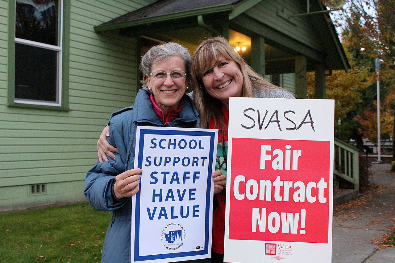 Ingrid Garhart of SVSD (left) and Shannon Smith of Snoqualmie Elementary (right) pose for a photo while picketing at the street corner of City Hall for a fair contract for district secretaries. Madison Miller/staff photo.