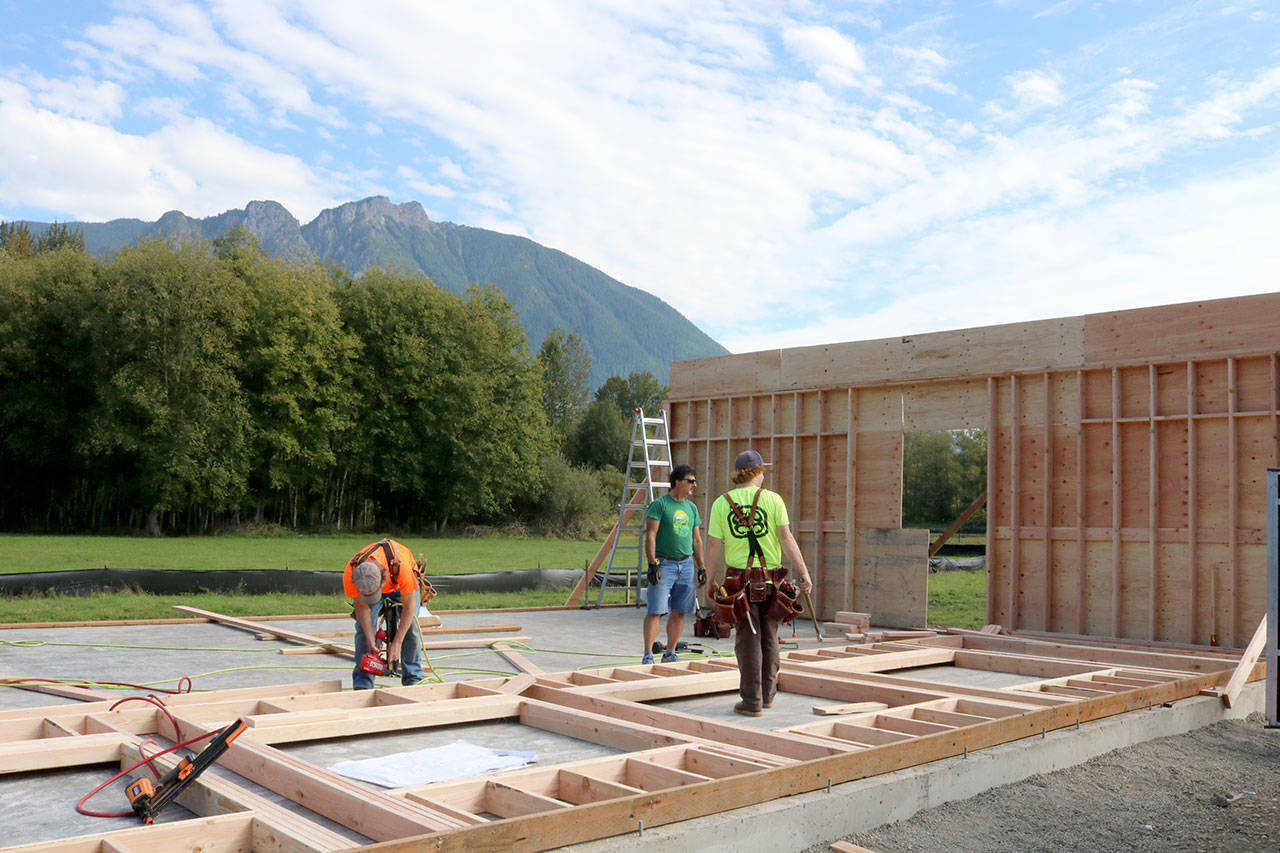 Volunteer crews work to build the walls of the main building on Saturday afternoon. Evan Pappas/Staff Photo