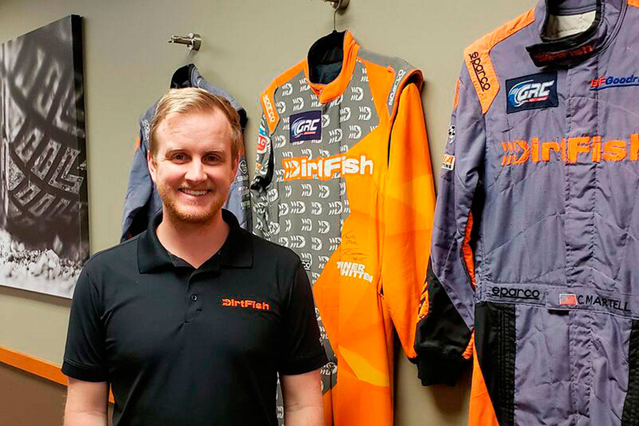 Dirtfish’s media manager Trevor Wert stands against a wall of suits worn by professional Dirtfish racers. Drew Stuart/ Staff Photo
