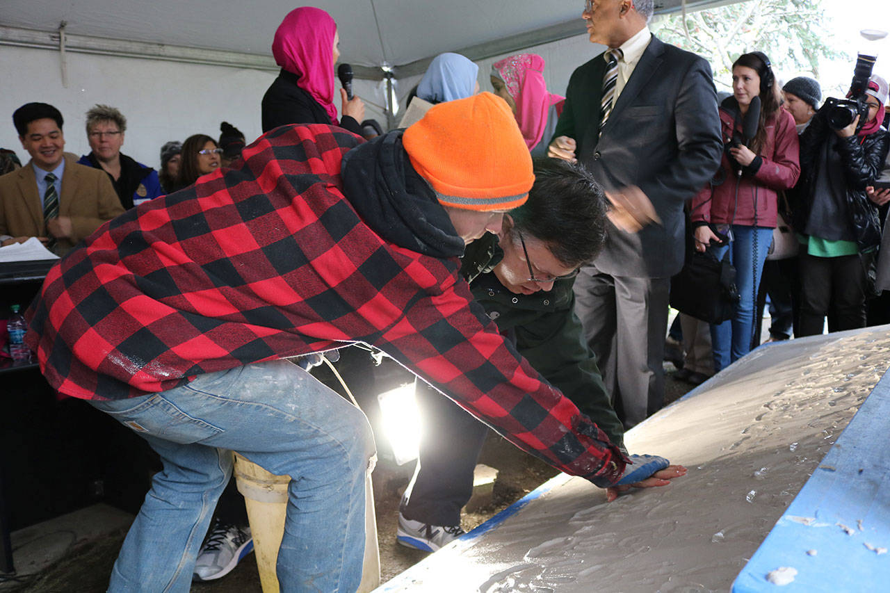 Mayor John Marchione was among many community members to place their handprints in the wet cement below the new sign at the Muslim Association of Puget Sound in Redmond after the mosque’s old sign was vandalized in 2016. File photo