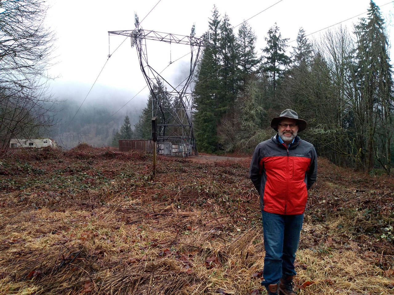 Thomas Speckhardt stands on his property line next to a power line easement in Issaquah. The line was recently reclaimed by Bonneville Power Administration from Puget Sound Energy and the company is hoping to expand vegetation clearance around it. Aaron Kunkler/staff photo