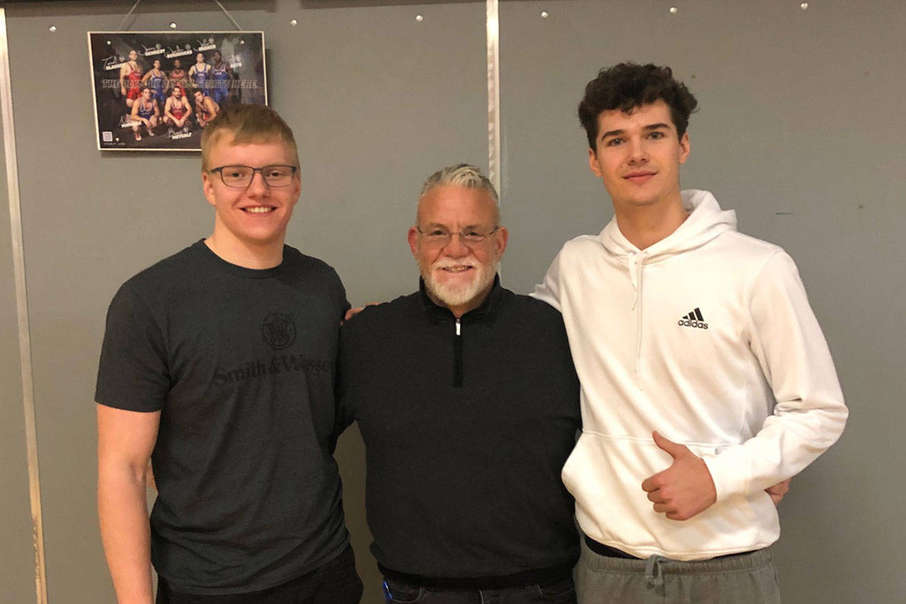 Mount Si lineman Cody Frederick, left, and Mount Si wide receiver Jonny Barrett, right, pose for a photo with Wildcats’ head coach Charlie Kinnune. Photo courtesy of Charlie Kinnune