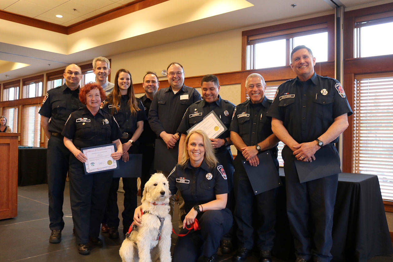 Volunteer Emergency Medical Service and Firefighters were recognized for their contribution to the city on April 10. From left, back row: Justin Venezia, Catherine Cotton, Mayor Matt Larson, Sara York, Tyson Adams, Thomas Walker, Paul Marrero, Robert Angrisano, Greg Prothman. Front row: Volunteer EMS Lorrie Jones, with Phoebe the Dog. Evan Pappas/Staff Photo