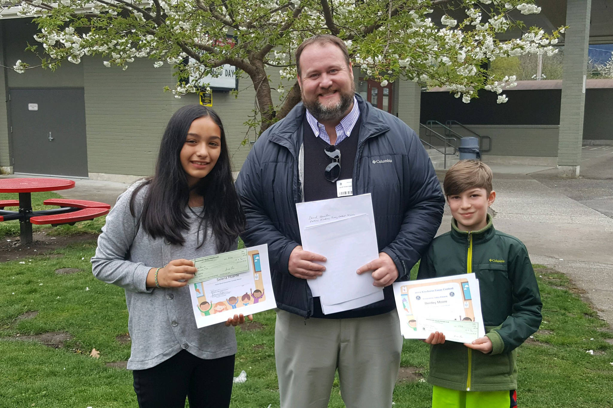 Courtesy photo                                David Hamilton of North Bend, center, presents checks to Kiwanis Kindness Essay contest winners Selena Huante, left, and Bentley Moore, both of North Bend Elementary. Other contest winners are Rebekah Baker and Kenahdie Wilkins, both of Fall City, Ellen Callahan and Claire Tougher, both of Cascade View, Lauren Blad of Timber Ridge, Hannah LaCroix of Parent Partnership, Asher Shuck of Snoqualmie Elementary, and Katie Holloway, Zachary Graham and Josef Treiber, all of Opstad.