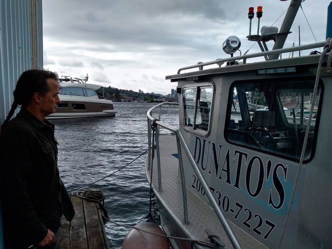 Corey Breuer, owner of Northwest Boat Disposal at Dunatos Boat Yard in Seattle shows a reporter one of three vessels which can lift sunken boats from King County waters and Puget Sound. Aaron Kunkler/staff photo