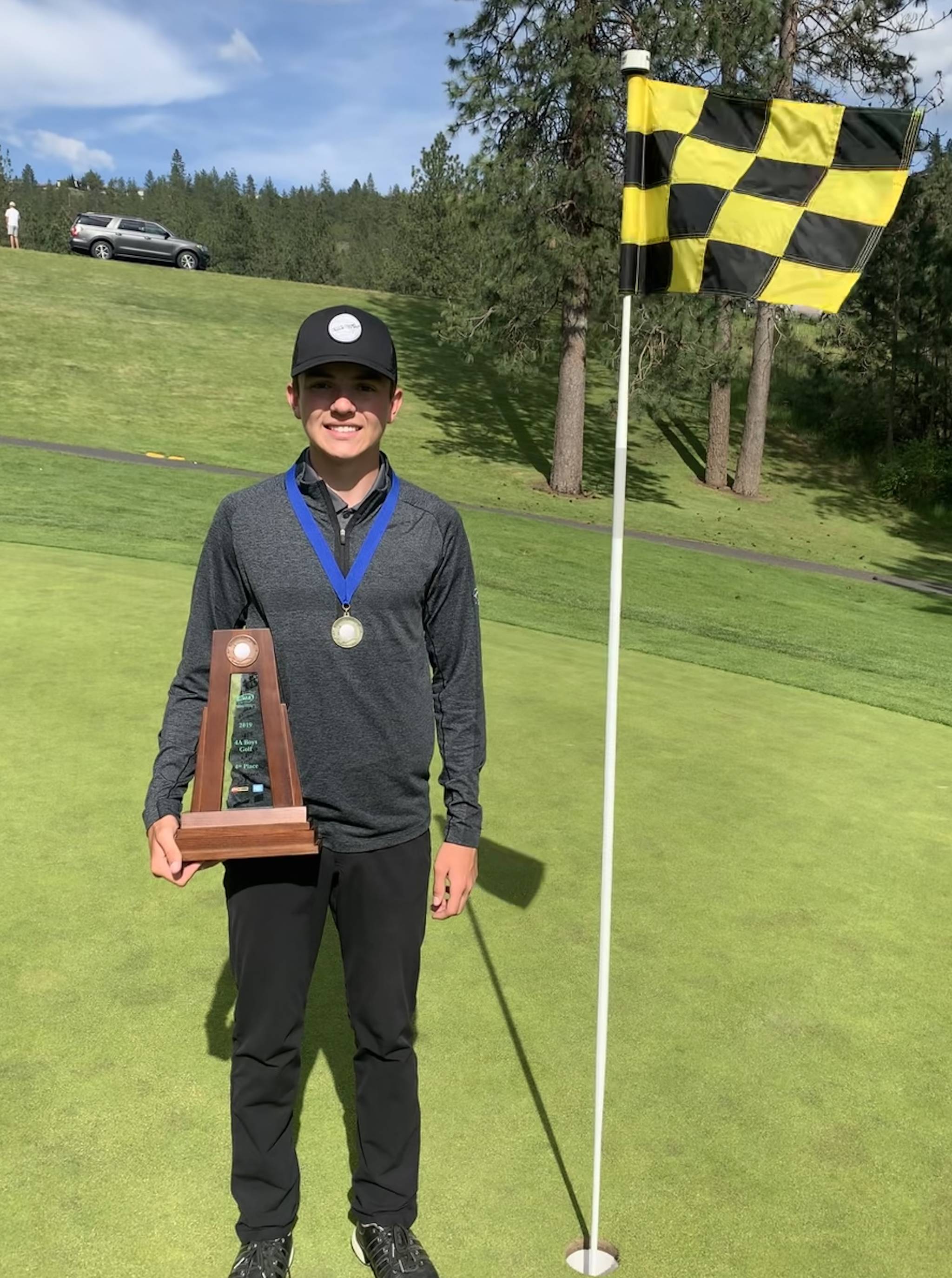 Mount Si’s Drew Warford sports his first-place medal and holds the team’s fourth-place trophy at The Creek at Qualchan Golf Course in Spokane. Courtesy photo