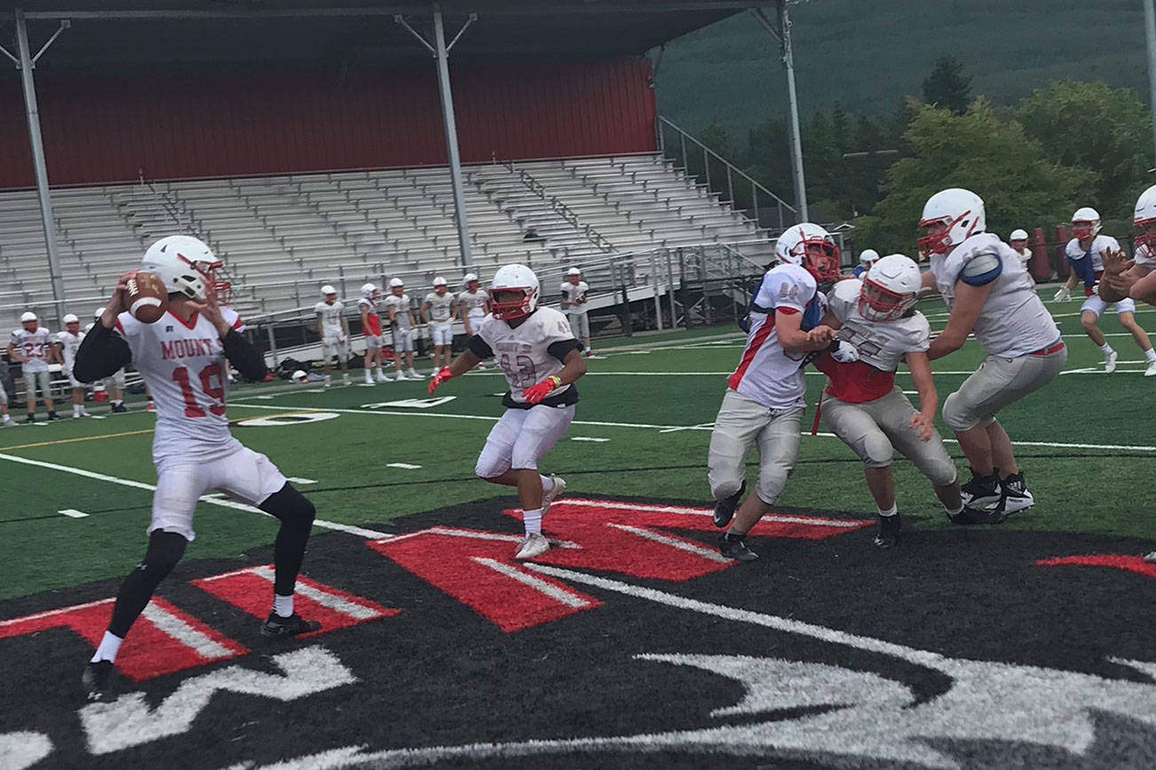 Mount Si Wildcats junior quarterback Clay Millen, left, drops back in the pocket before delivering a pin-point pass during a spring practice session on June 6 at Mount Si High School in Snoqualmie. Shaun Scott/staff photo