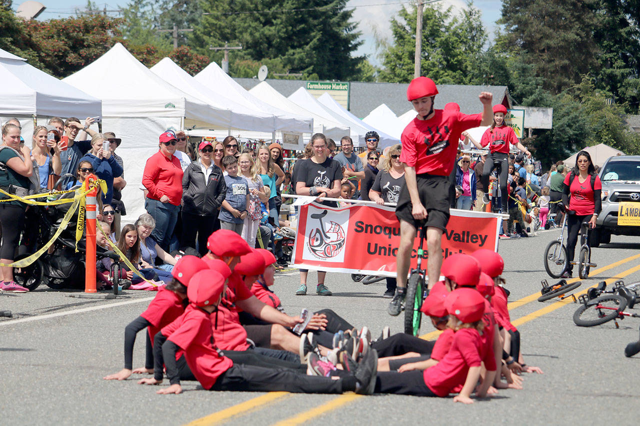 The Snoqualmie Valley Unicycle Club attempts a big jump stunt during the parade. Evan Pappas/Staff Photo