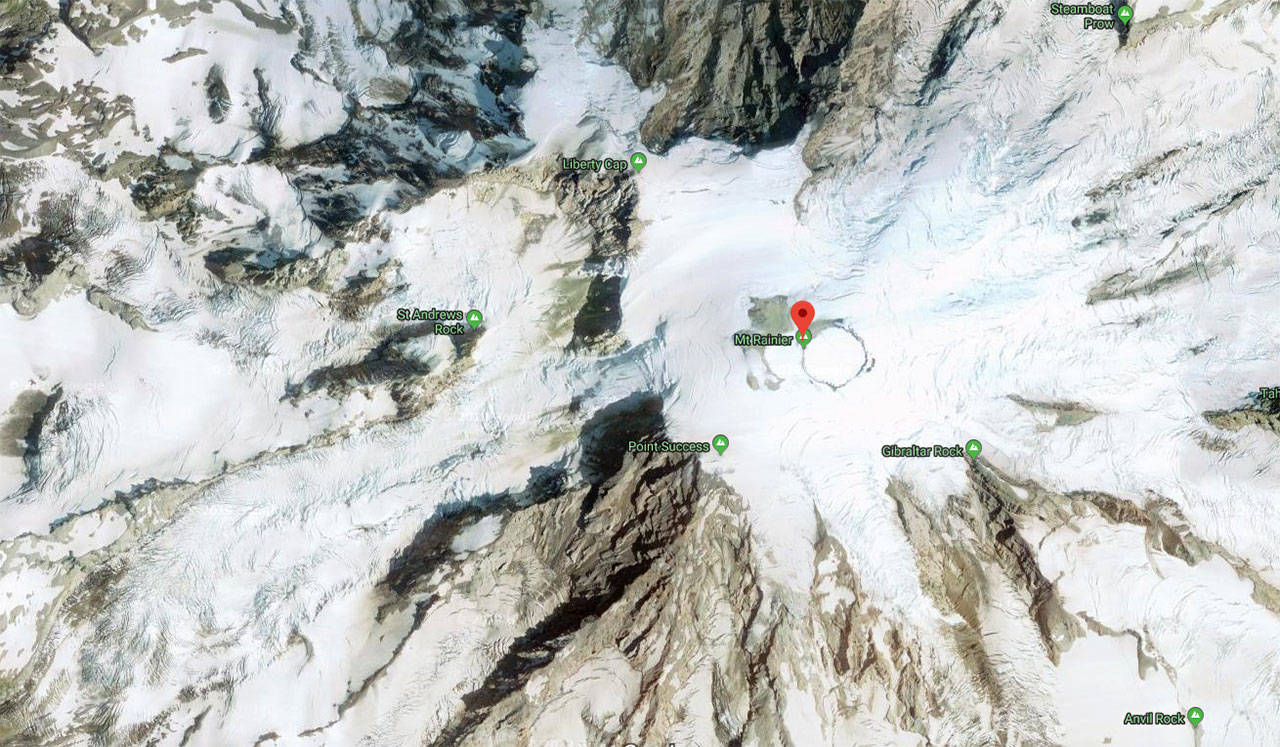 An aerial photo of Mount Rainier. The rescued climbers were found between Liberty Cap, the mountain’s smallest peak, and Columbia Crest, it’s tallest, marked with the red pointer. Image courtesy Google Maps