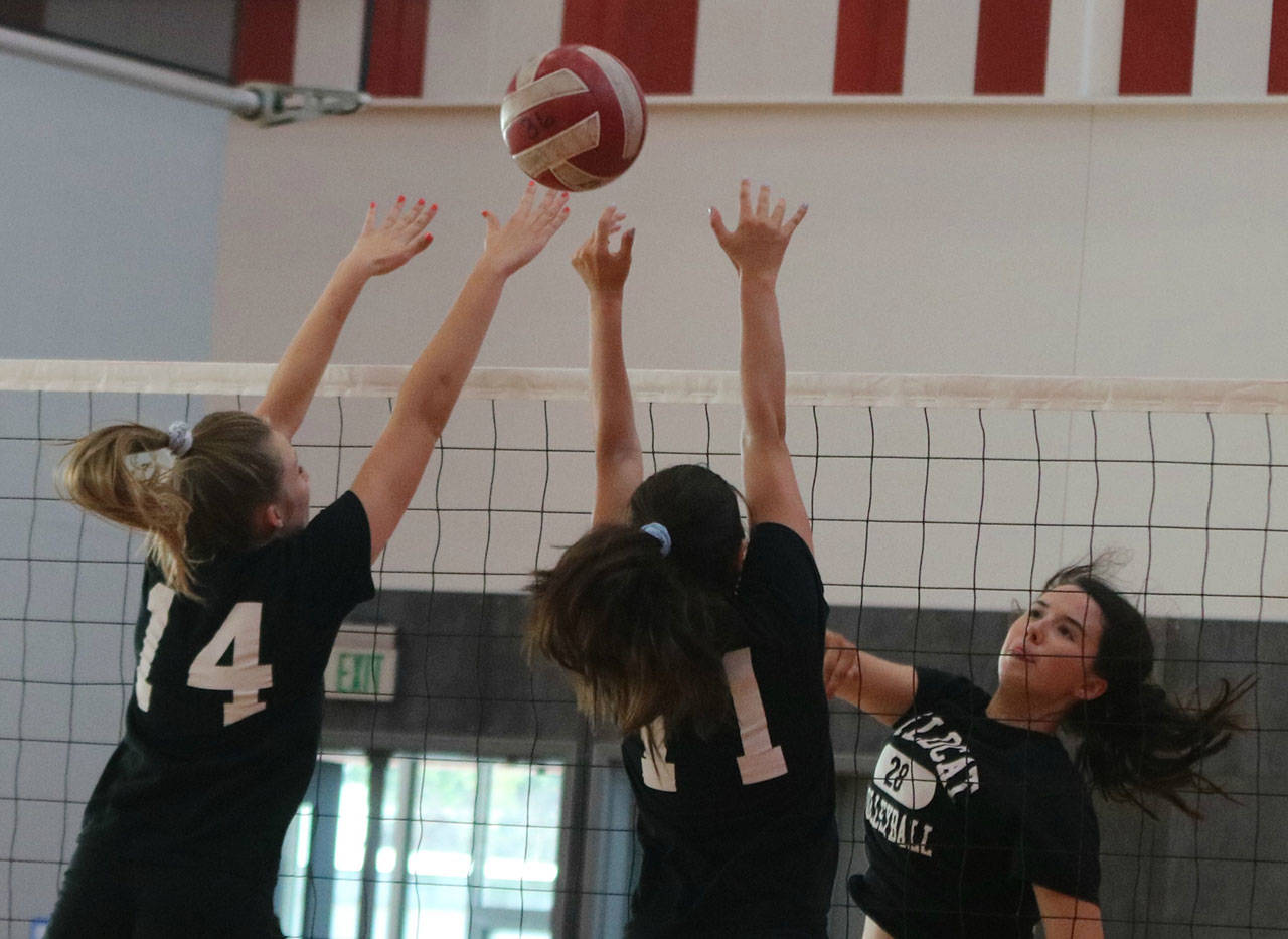 Mount Si volleyball players attack the net during practice on Sept. 5 in their new gym. Emily Dann, Dana Dolan and Megan Underbrink are pictured. Andy Nystrom/ staff photo