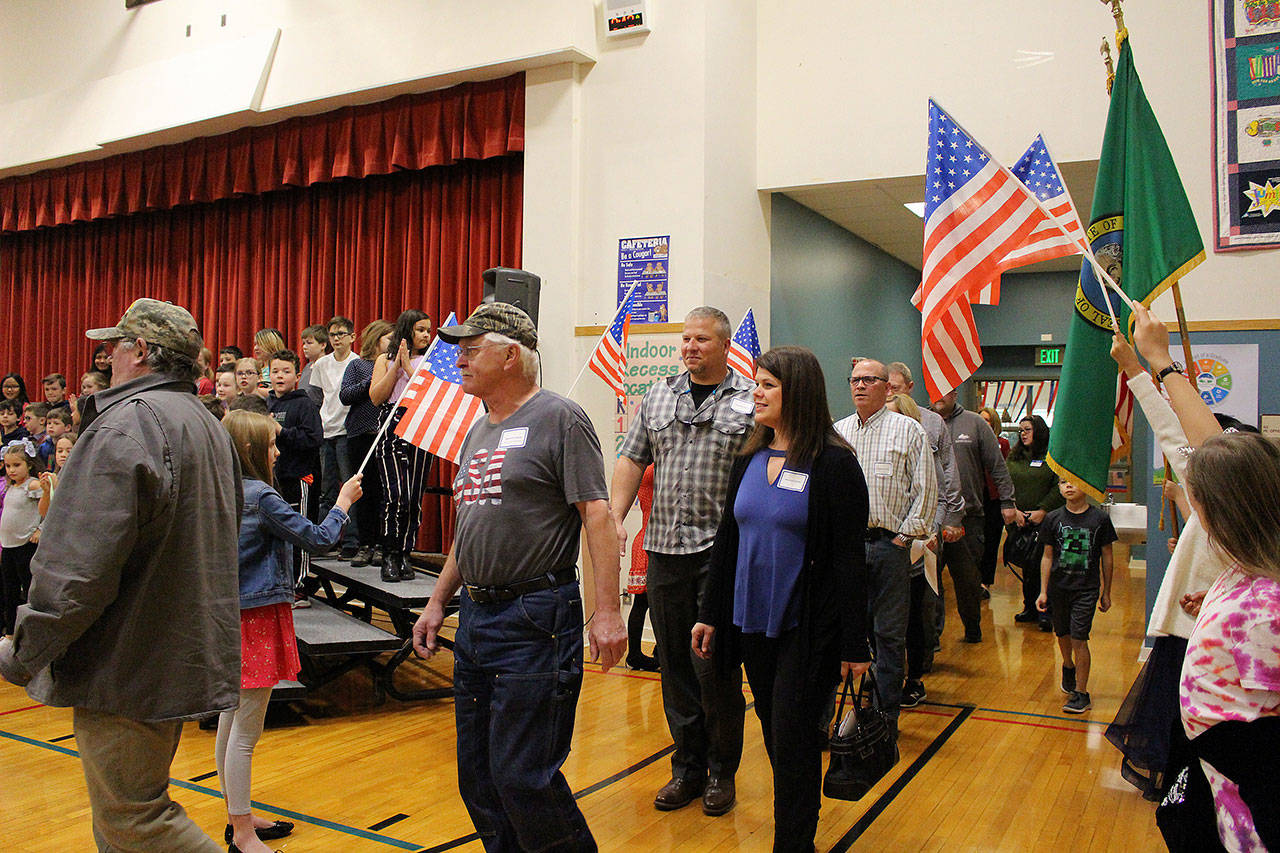 Desi Cuddihy’s fourth-grade students welcome veterans, including Navy veterans Mark and Angie Kennedy (center) as they enter the Snoqualmie Elementary Veterans Day assembly on Nov. 8. Madison Miller / staff photo