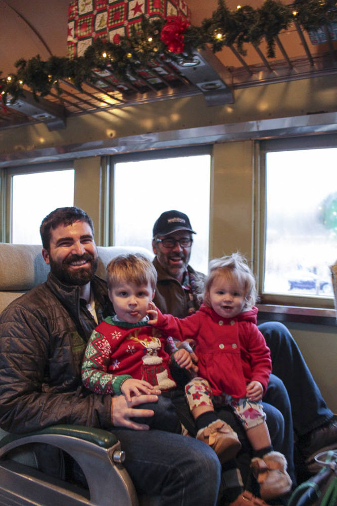 Natalie DeFord/staff photos                                 From left, Sam Turner and Rob Turner holding 3-year-old Owen and 1-year-old Nora as they ride the Northwest Railway Museum’s 50th annual Santa Train.