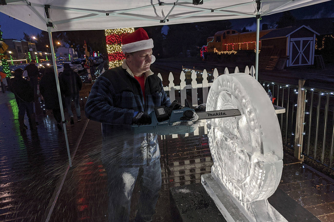Ice carver Brian Mitchell of Seattle carves a work commemorating the 50th anniversary of the Northwest Railway Museum’s Santa Train. It took Mitchell about two hours to complete the work, a combination of three separate pieces fuzed together. Corey Morris/staff photo