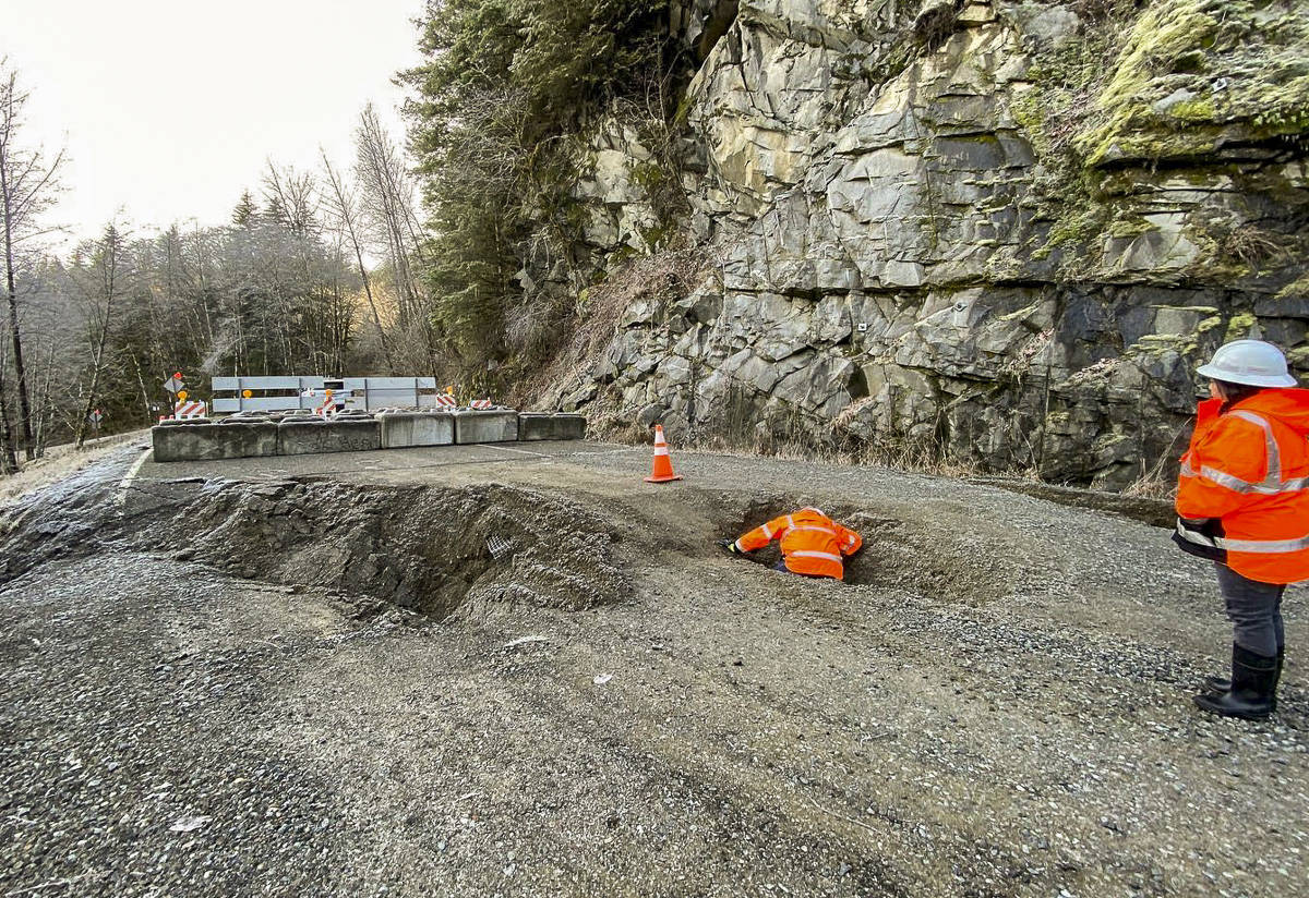 Beyond a clearly marked barricade, King County Road Services workers conduct a brief initial assessment of a landslide that occurred on Dec. 20, severely damaging Middle Fork Road, which will remain closed for an unknown extended period of time. It is extremely dangerous for pedestrians and bike traffic to go around the barricade. Photo courtesy of King County Road Services.