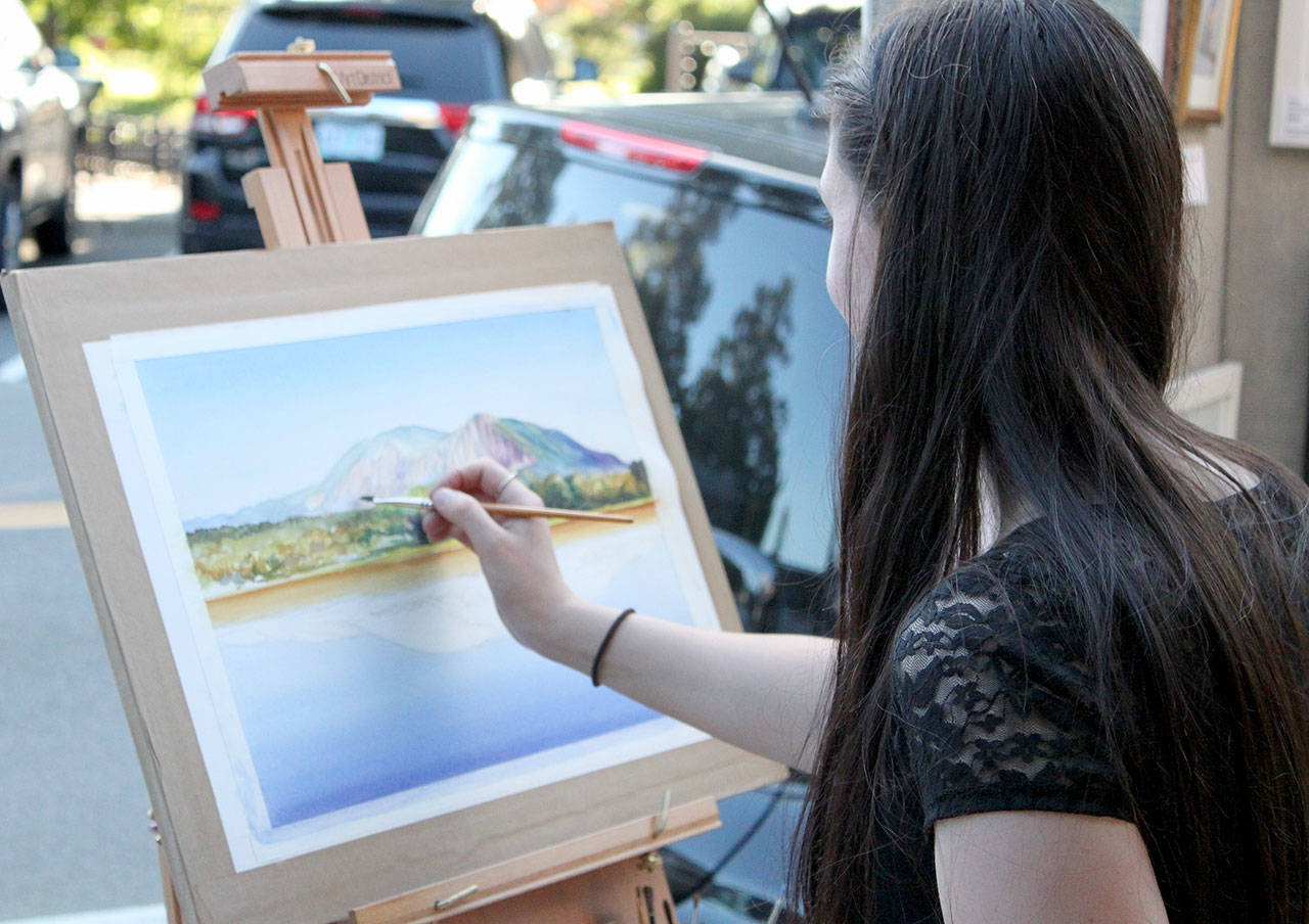 Jacqueline Tribble painting during a previous Finally Friday Art and Wine Walk event. Courtesy photo