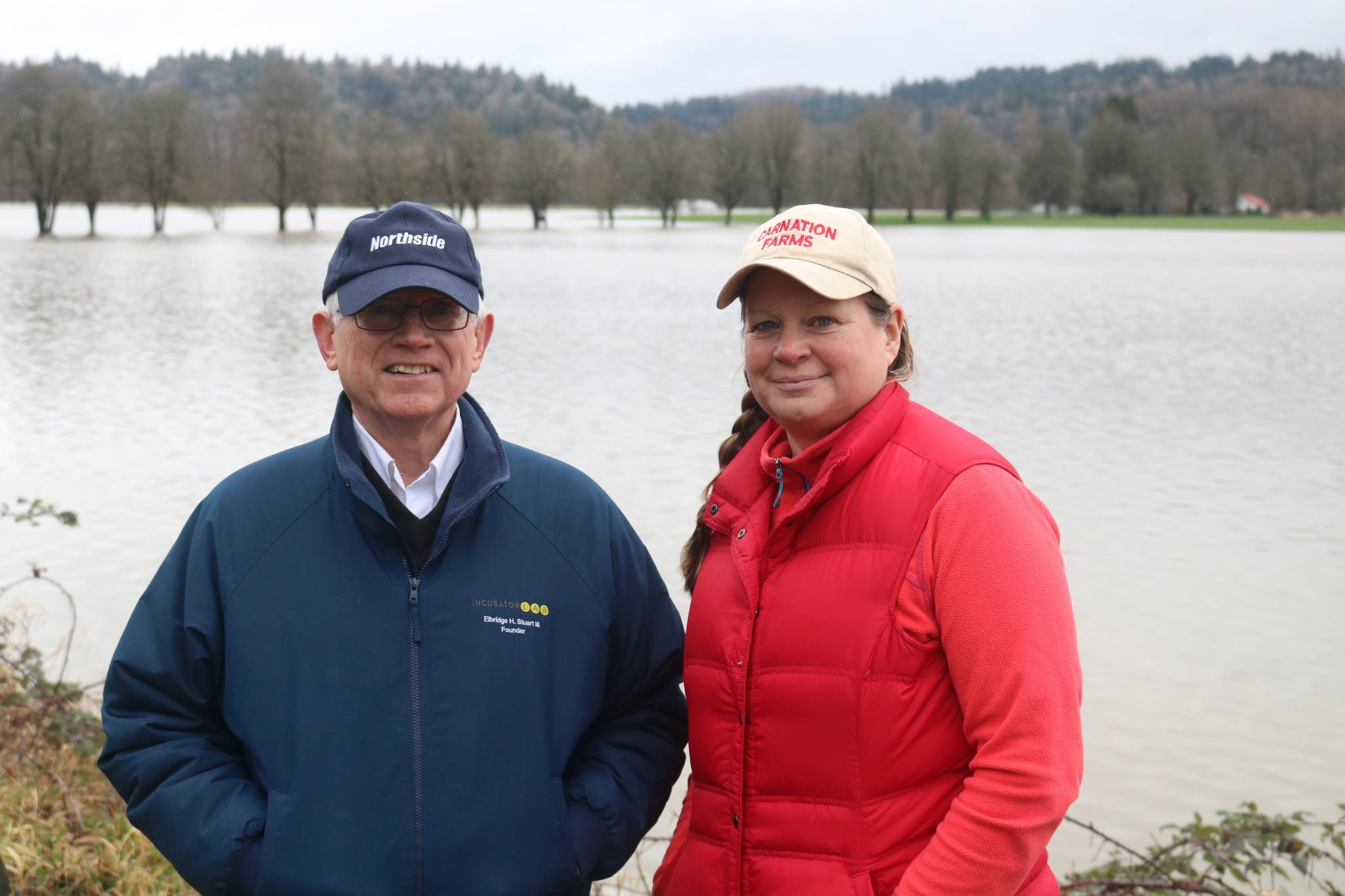 Elbridge Stuart and Rosy Smit stand in front of Carnation Farms’ flooded fields on Feb. 7, 2020. It’s the fifth flood this year along the Snoqualmie River that has broken 56 feet. File photo