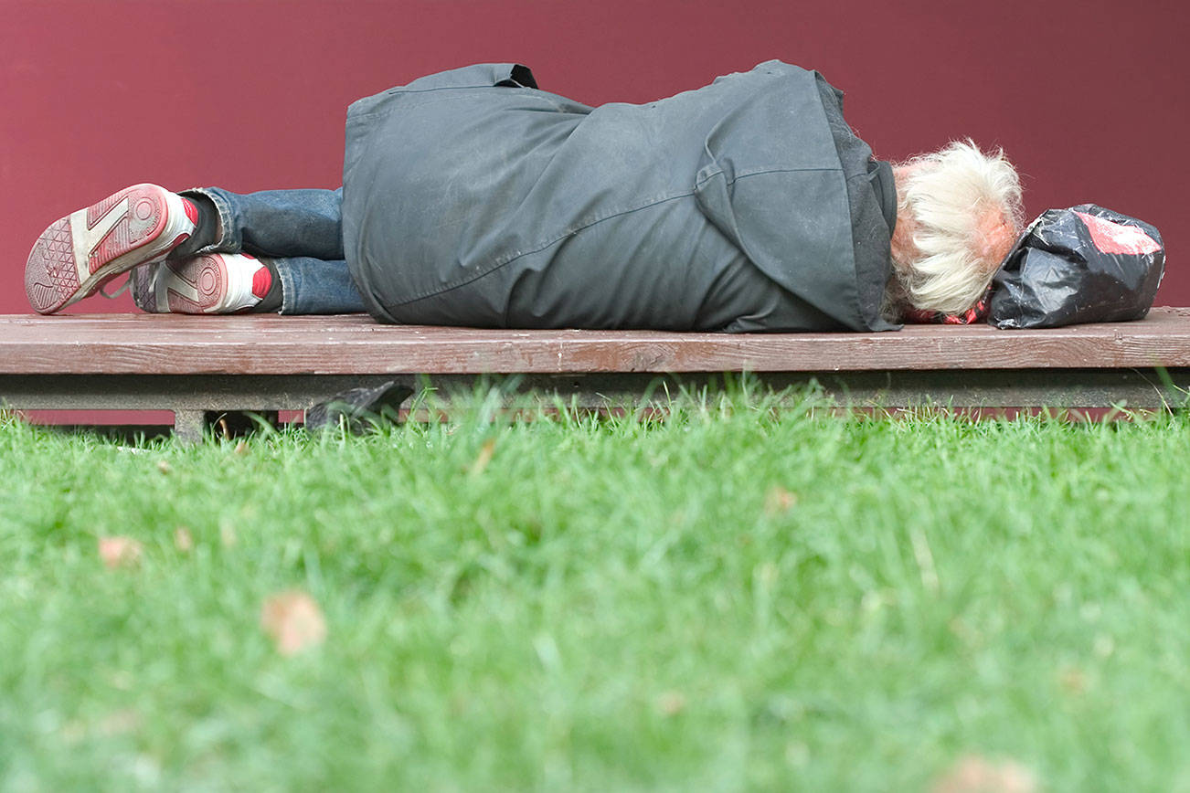 Homeless man lying on the bench. File photo