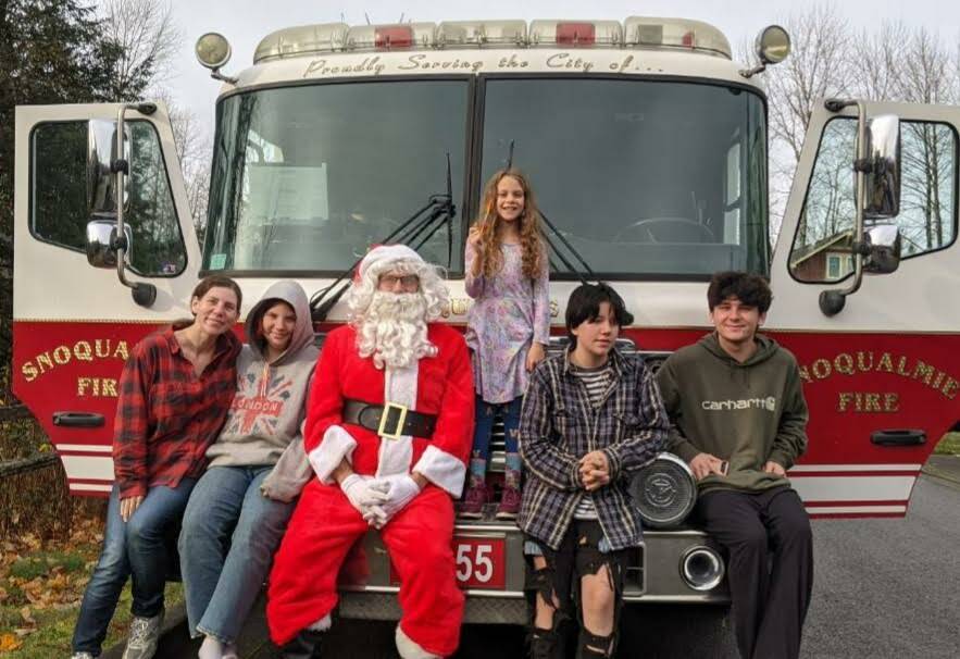 Santa Claus poses with the Hayden family in Snoqualmie. From left to right:  Jennifer, Amy, Ilyana (standing), Arielle and Ian. Photo courtesy of Snoqualmie Firefighters Association.