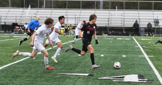 Photo courtesy of Calder Productions. Sophomore Zach Ramsey dribbles past two defenders in a 1-0 lose to East Valley (Yakima) on March 26. The Wildcats are off to a 2-1-2 record this season. They open conference play against North Creek on March 29.