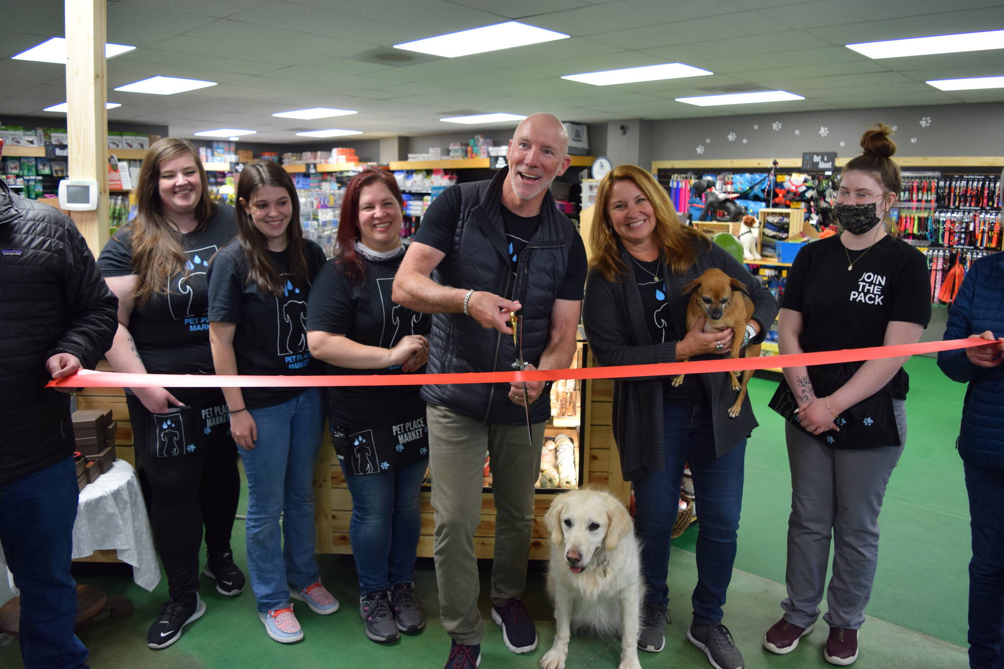 Owners Chris and Amy Hawkins (center) celebrate the 15 year anniversary and grand re-opening of Pet Place Market in North Bend on April 20, alongside staff and their dogs: Nala (l) and Jazzy. Photo Conor Wilson/Valley Record.