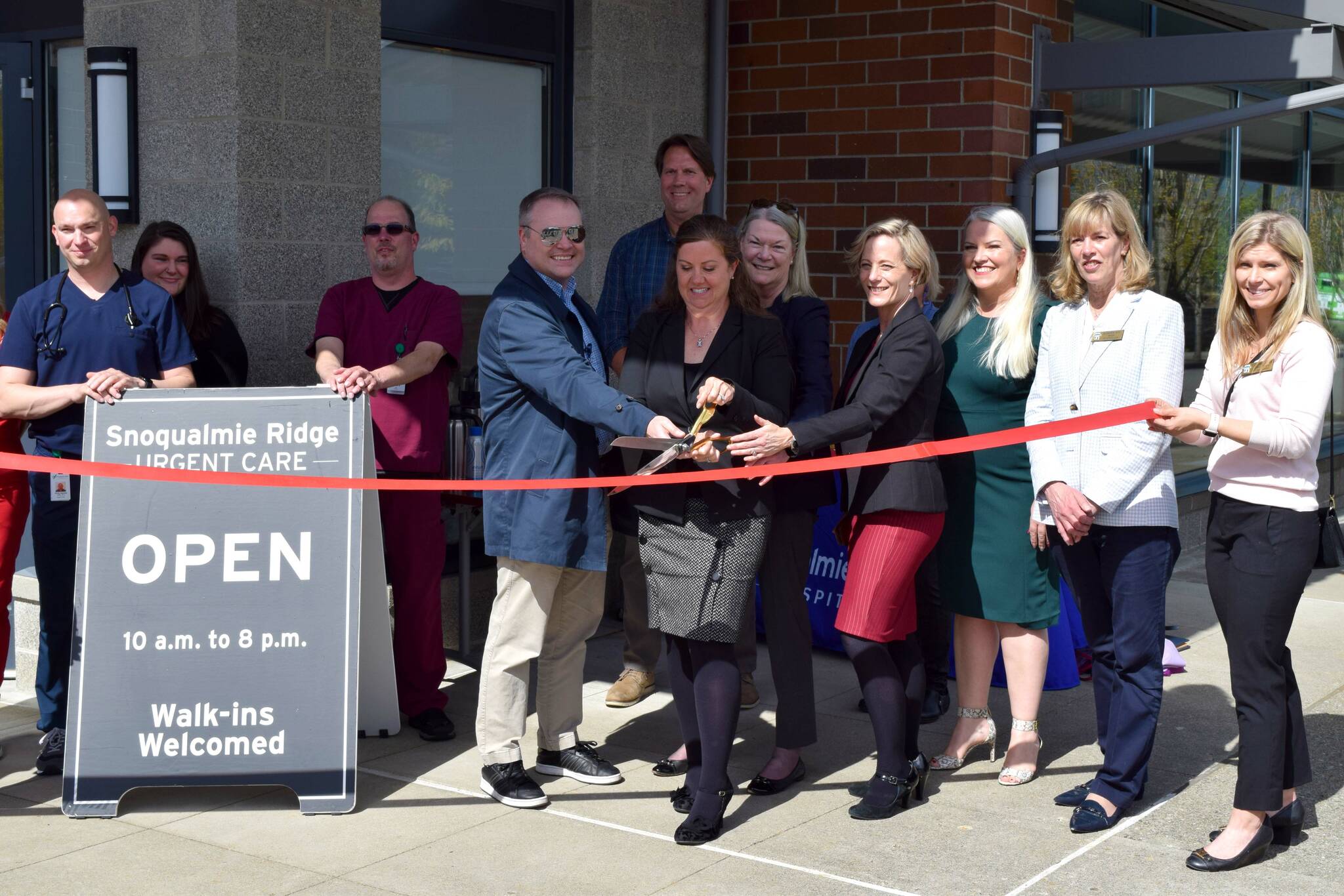 Snoqualmie Valley Hospital CEO Renee Jensen (center) is joined by hospital staff and Snoqualmie elected officials to celebrate the opening of the Snoqualmie Ridge Urgent Care on May 4. Photo Conor Wilson/Valley Record.