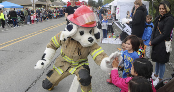 File photo 
The Fall City Fire Department’s mascot high fives kids during the Fall City Day Parade.