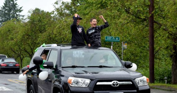 Two boys celebrate during the Fall City Graduate Parade on June 17. Photo Conor Wilson/Valley Record.