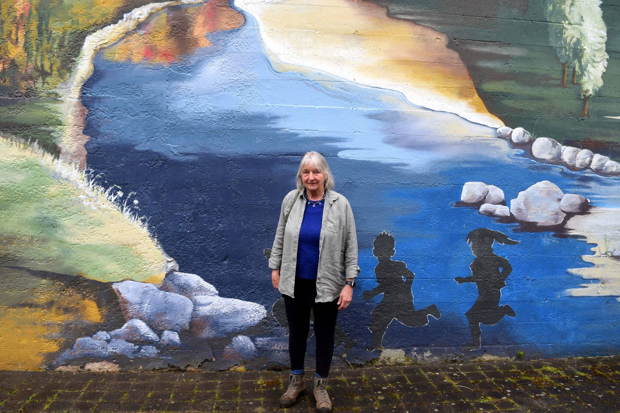 Barbara Center poses in front of a mural at Fall City Art Park. Photo by Conor Wilson/Valley Record