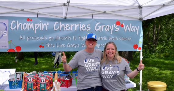 Summer Stumpf (l) founder of nonprofit, Live Gray’s Way, poses in her booth at Fall City Days. File photo by Conor Wilson/Valley Record