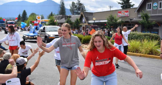 Members of Mount Si High School’s basketball team high-five parade spectators during the Festival at Mt Si. All photos Conor Wilson/Valley Record.