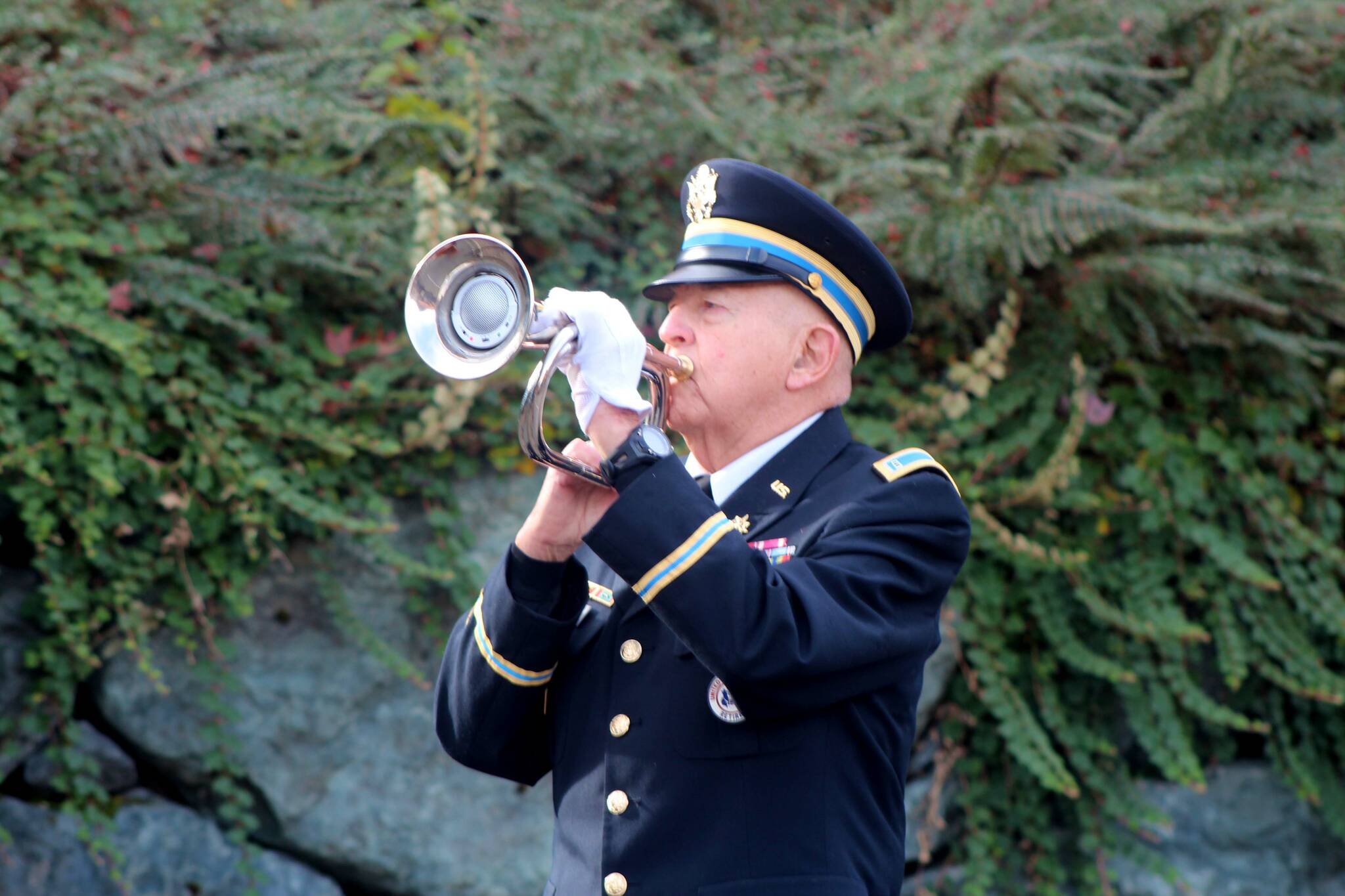 Art Farash, an Army Veteran and American Legion Post 79 member, plays TAPS during a flag ceremony.