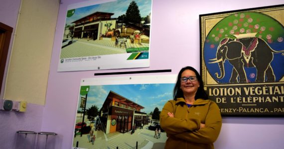 Ana Cortez, Carnation’s city manager, poses in front of designs for the new city hall building being built at the old library site. Photo by Conor Wilson/Valley Record