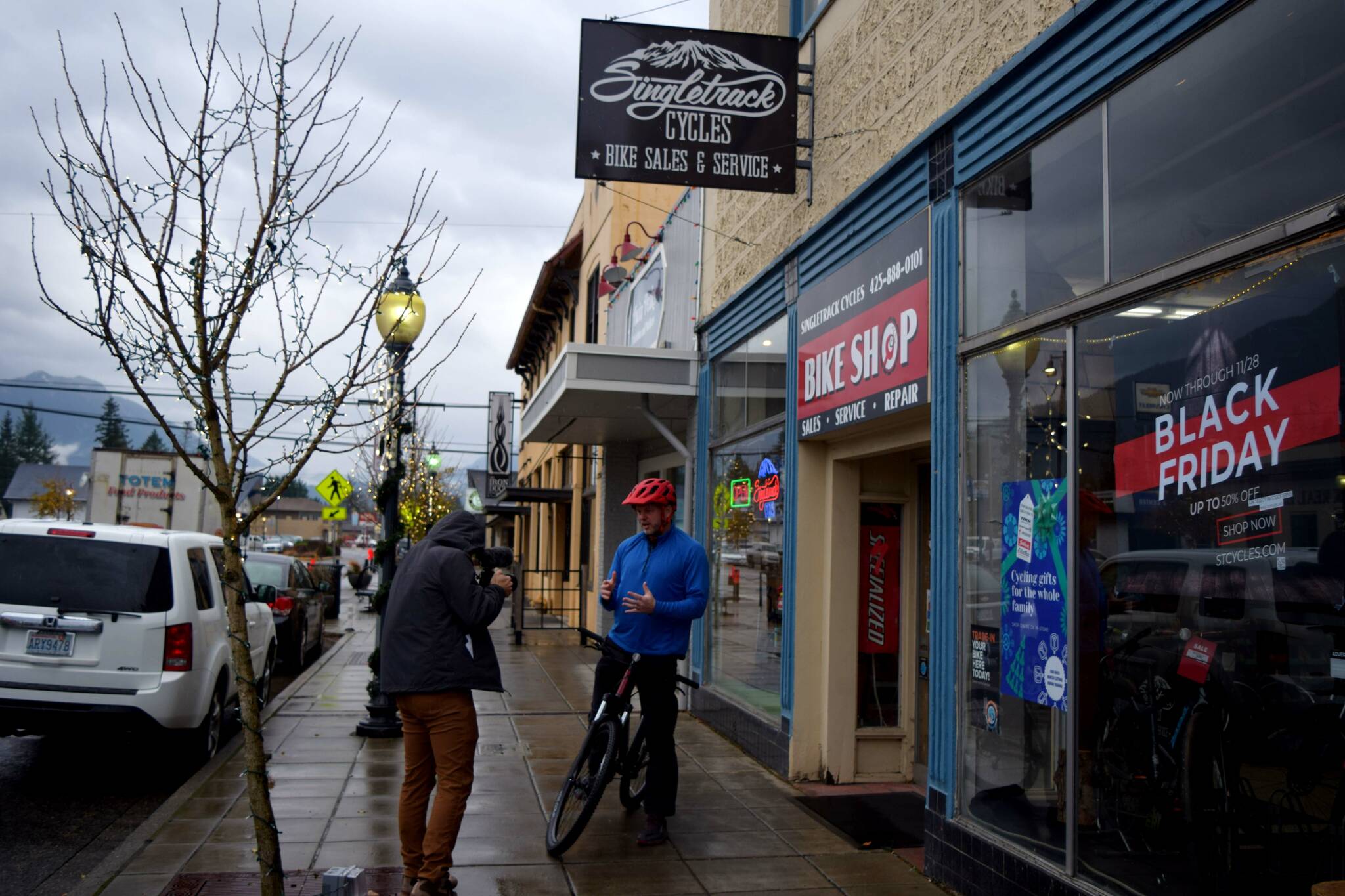 All Photos by Conor Wilson/Valley Record.
Brian Davis films outside of Singletrack Cycles in downtown North Bend on Nov. 22.