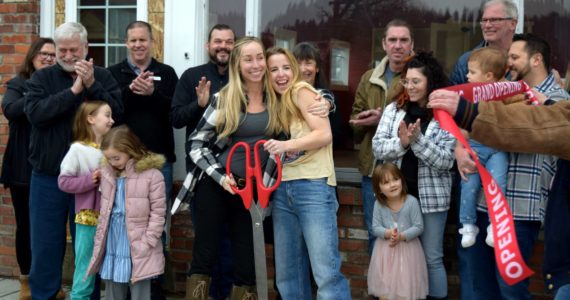 Katie Black (left) and Brittany Mains (center), owners of IGNITE Dance Carnation, hug during their ribbon cutting ceremony on March 4. Photo by Conor Wilson/Valley Record