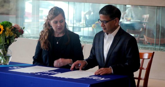 Snoqualmie Valley Health CEO Renee Jensen, left, and Shalabh Chandra, president of Spacelabs Healthcare, sign a parternship agreement at Snoqualmie Valley Hospital on March 6. Photo Conor Wilson/Valley Record.