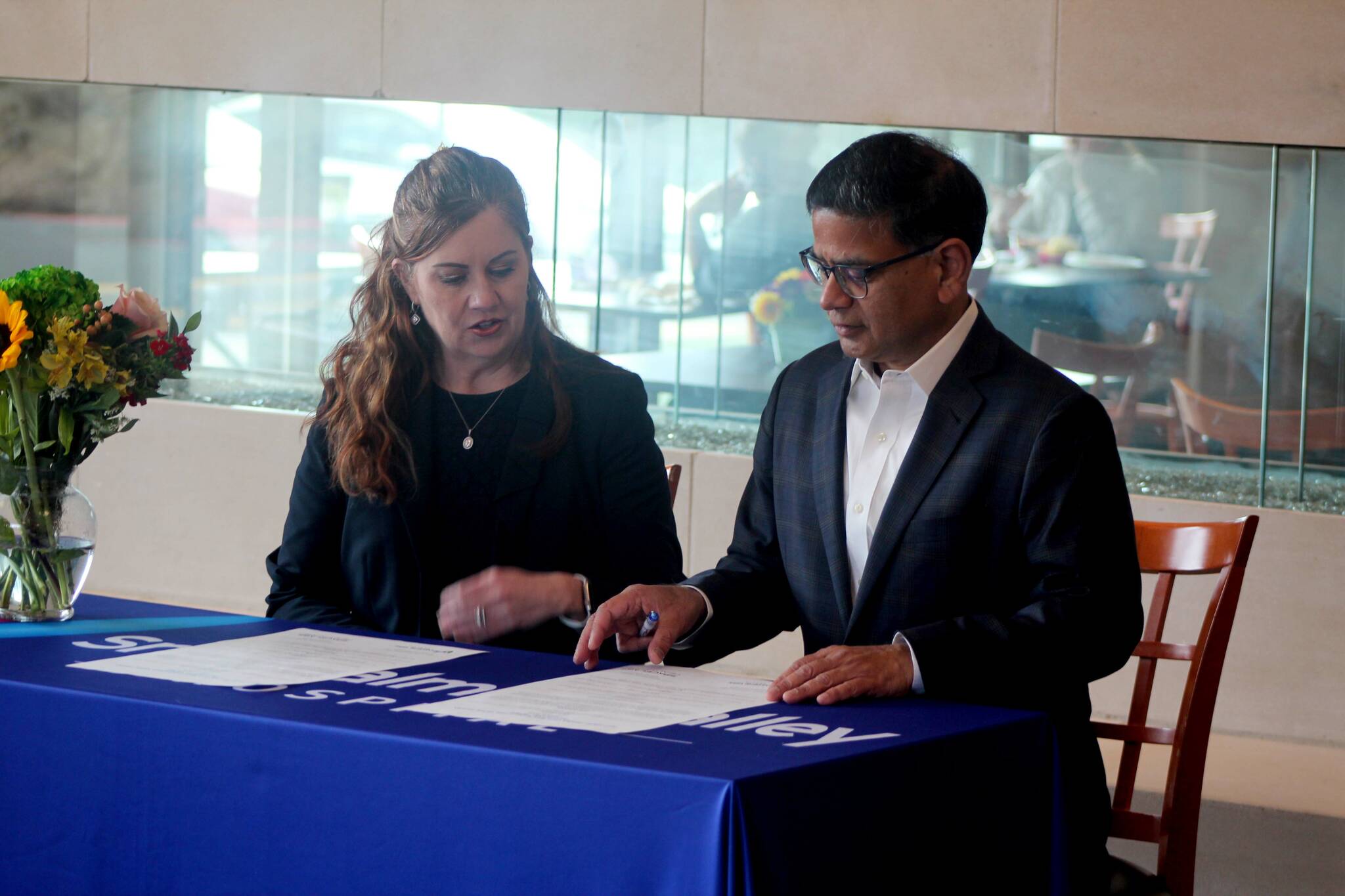 Snoqualmie Valley Health CEO Renee Jensen, left, and Shalabh Chandra, president of Spacelabs Healthcare, sign a parternship agreement at Snoqualmie Valley Hospital on March 6. Photo Conor Wilson/Valley Record.