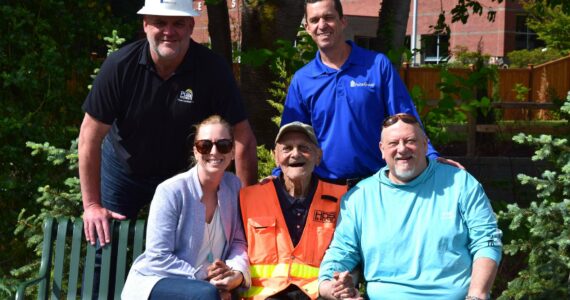Burt Mann (bottom center) poses for a photo with community members who helped install a sprinkler system at his garden. Top row, from left: Tom Gallagher and Dan Waddell. Bottom Row: Meghan Remington, Mann and Tom Armour. Photo by Conor Wilson/Valley Record.