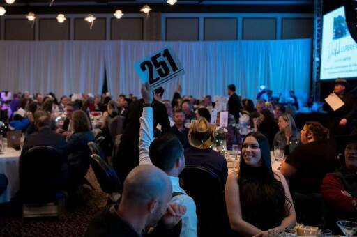 <p>Event attendees participating in the 2023 SnoValley Color Ball live auction. Photo courtesy of Kelly Coughlin</p>
