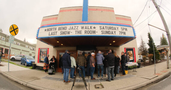 The thirteenth annual North Bend Jazz Walk was held April 27. Nineteen venues throughout downtown North Bend hosted 28 jazz bands with at least 100 total musicians from 5 p.m. to midnight. Learn more at northbendjazzwalk.com. Pictured: Excited guests hide from the rain under the cover of the North Bend Theatre. Photos by Ben Magnus/For the Valley Record
