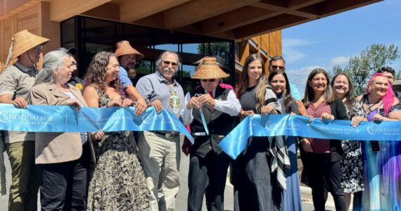 Robert de los Angeles, chairperson of the Snoqualmie Tribal Council, cuts the ribbon at the opening of the Snoqualmie Casino’s hotel, surrounded by tribal members, Aug. 8, 2025. (Grace Gorenflo/Valley Record)