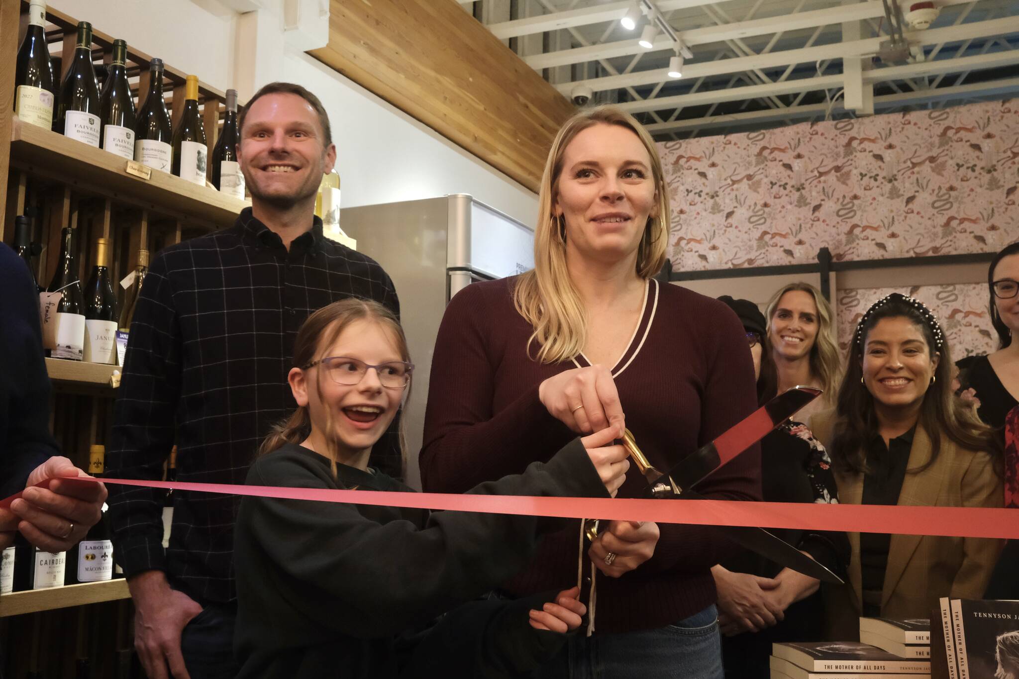 Books and Bottles owner Julie Thomas prepares to the cut the ribbon on her shop, joined by her husband and daughter, Nov. 14, 2025. Grace Gorenflo/Valley Record