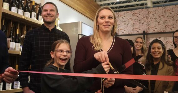 Books and Bottles owner Julie Thomas prepares to the cut the ribbon on her shop, joined by her husband and daughter, Nov. 14, 2025. (Grace Gorenflo/Valley Record)