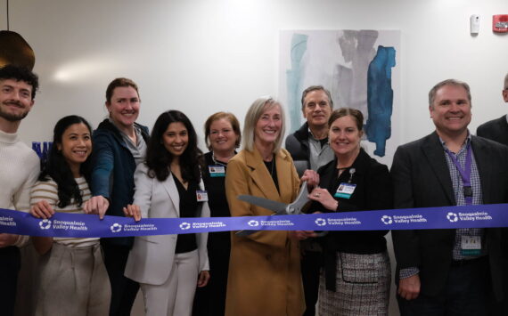 Snoqualmie Valley Health CEO Renee Jensen (right) and North Bend Mayor Mary Miller cut the ribbon on the new clinic, Nov. 19, 2025. They are surrounded by SVH providers and leaders. (Grace Gorenflo/Valley Record)