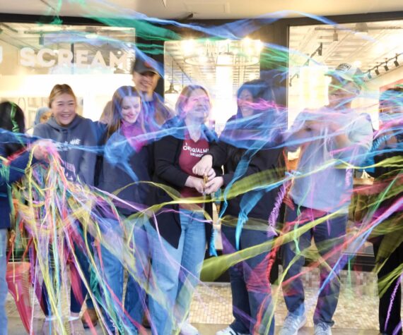 <p>Snoqualmie Ice Cream co-owners Heather Dean and Julie Chung, with their families, cut the ribbon at their grand re-opening, Nov. 19, 2025. (Grace Gorenflo/Valley Record)</p>