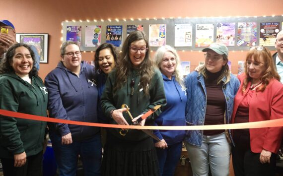Ellen Rowan, a North Bend Art & Industry co-founder and the Center for Creativity’s first staff member, prepares to the cut the ribbon, Dec. 8, 2025. (Grace Gorenflo/Valley Record)